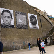 Enlarged photos (triptych) of immigrant boy, placed on outside wall in Margate