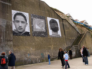 Enlarged photos (triptych) of immigrant boy, placed on outside wall in Margate